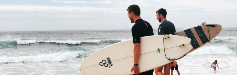 Surf morbihan. Deux hommes s'appretant à entrer dans l'eau avec leur planche de surf